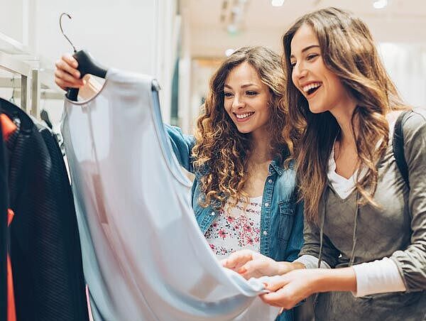 Consumers Shopping for Sustainable Fashion Two women looking at a shirt in a retail store