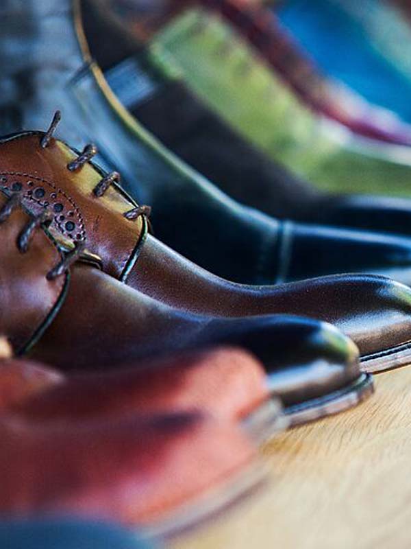 Tested and Certified Leather Footwear leather shoes and boots in several colors, lined up on a shelf