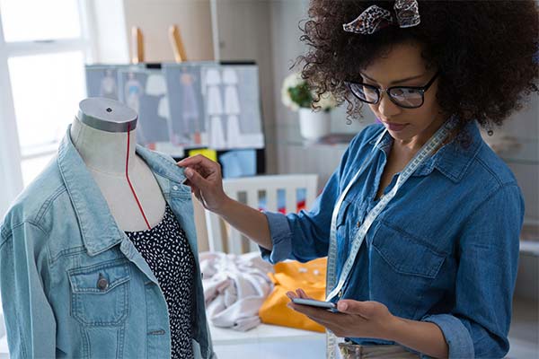 Designer working with jean jacket and dress on bust
